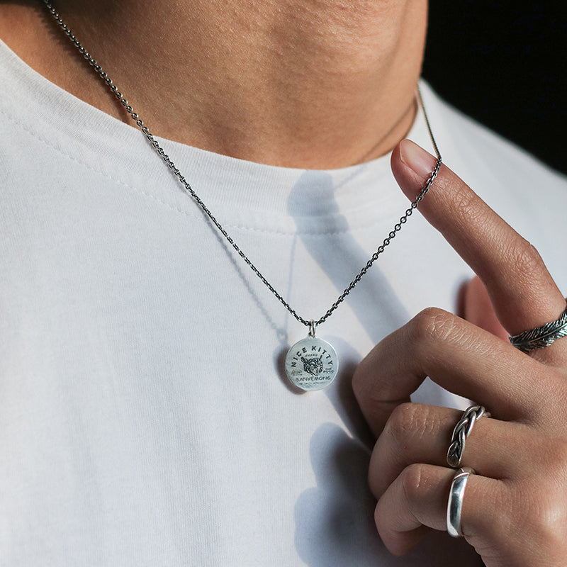 “Male model wearing minimalist unisex cat pendant necklace streetwear”