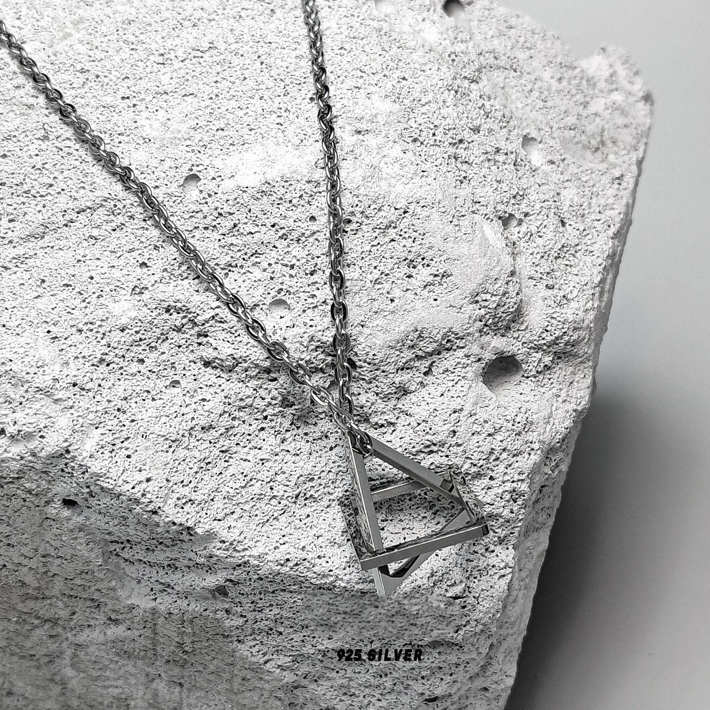 “Close-up of geometric sculptural pendant in solid sterling silver”