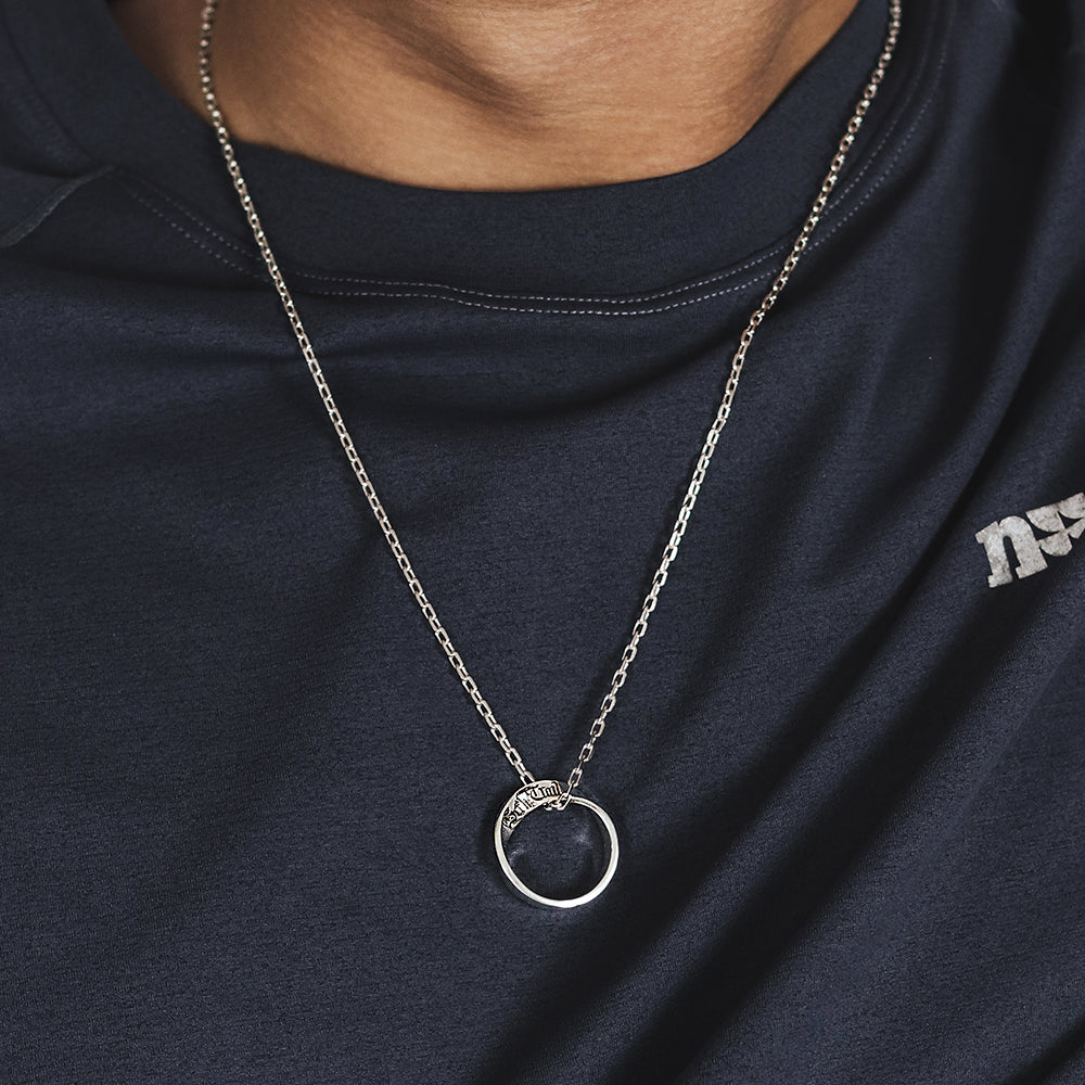 “Male model wearing minimalist Möbius infinity pendant silver necklace”