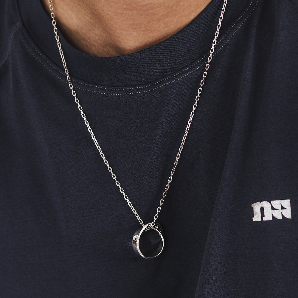 “Male model wearing minimalist Möbius infinity pendant silver necklace”