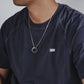 “Male model wearing minimalist Möbius infinity pendant silver necklace”
