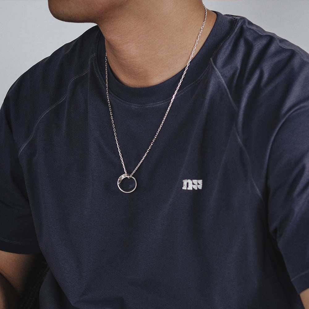 “Male model wearing minimalist Möbius infinity pendant silver necklace”