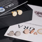 Gold moissanite studs on neutral background. Alt: “18K Gold Moissanite Round Earrings – 925 Silver Unisex.”