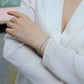 Bracelet stacked with other pieces. Alt: “Stackable Elegance: Moissanite Tennis Bracelet.”
