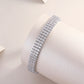 White gold three-row moissanite bracelet on neutral background. Alt: “Multi-Row Moissanite Bracelet – White Gold.”