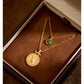 Two gold necklaces with pendants on a brown velvet surface