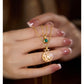 Gold necklaces with pendants on a hand against a blurred background