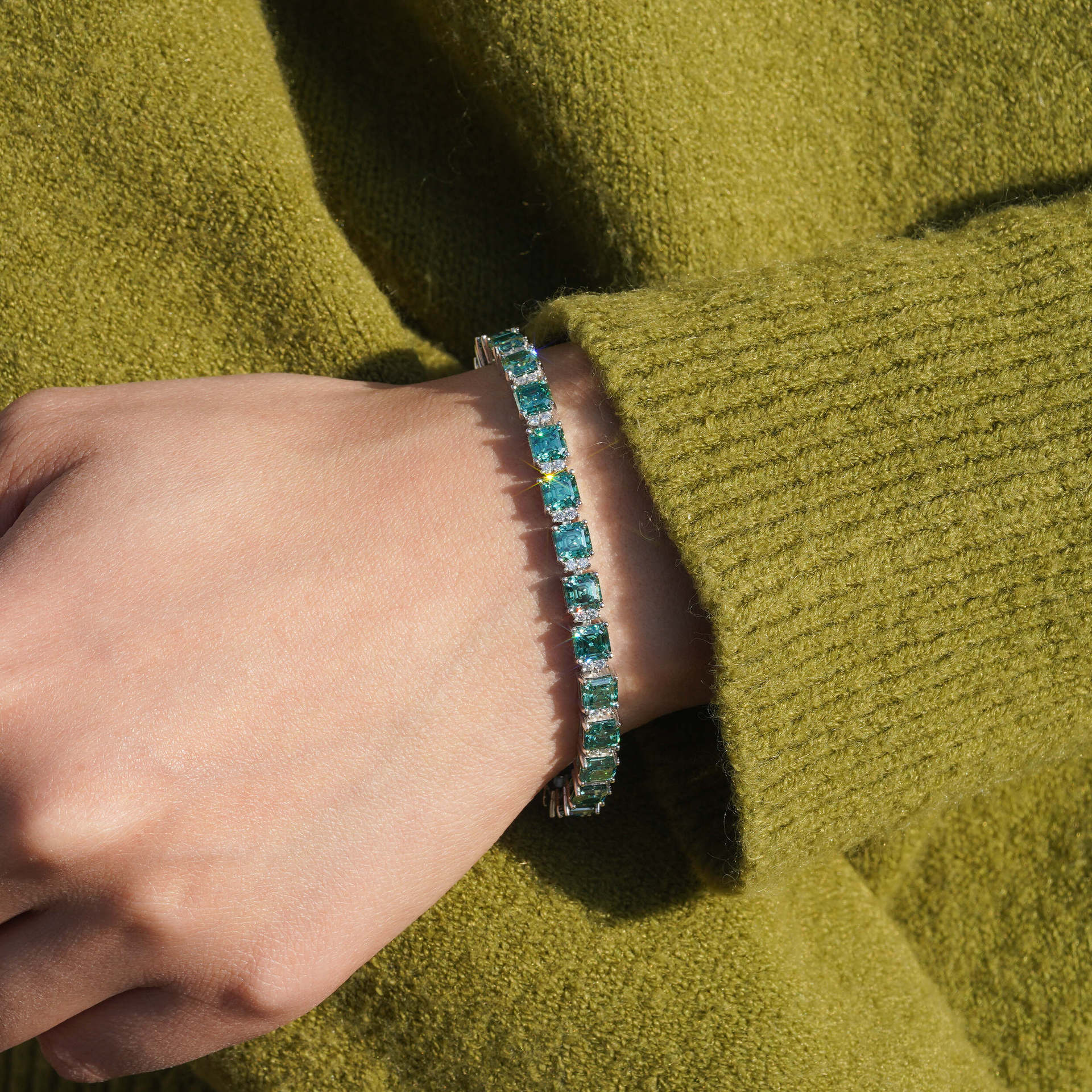  Include close-up shots showing the blue-green stones against the skin and wider shots showing the bracelet as part of an outfit.