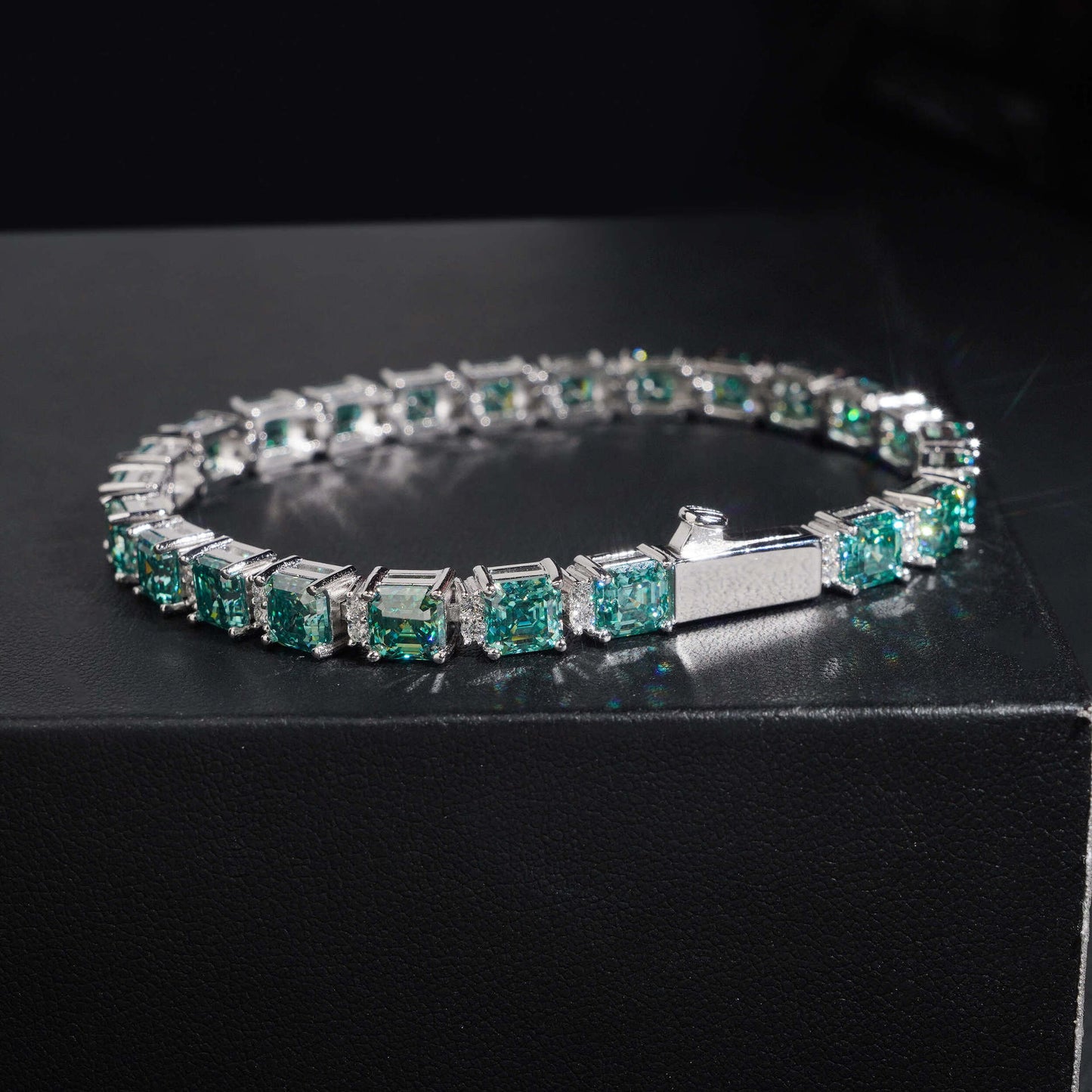 Straight-on to clearly showcase the square Asscher-cut stones and their blue-green color.

