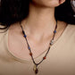 Necklace with beads worn by a person, close-up shot.