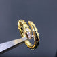 Gold hoop earrings with embedded stones on a dark background