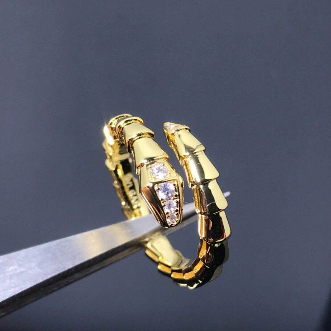 Gold hoop earrings with embedded stones on a dark background