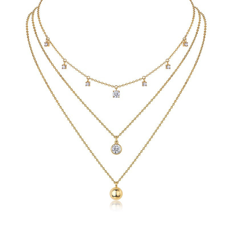 Clean white background — the round moissanite solitaire and polished ball pendant, each on its own chain, layered elegantly on a bust form. The round solitaire catches bright light with classic brilliant sparkle, while the ball pendant offers a smooth, reflective contrast. 