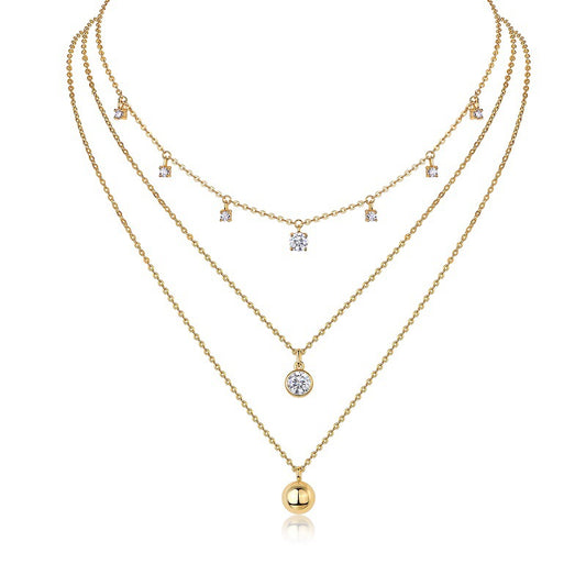 Clean white background — the round moissanite solitaire and polished ball pendant, each on its own chain, layered elegantly on a bust form. The round solitaire catches bright light with classic brilliant sparkle, while the ball pendant offers a smooth, reflective contrast. 
