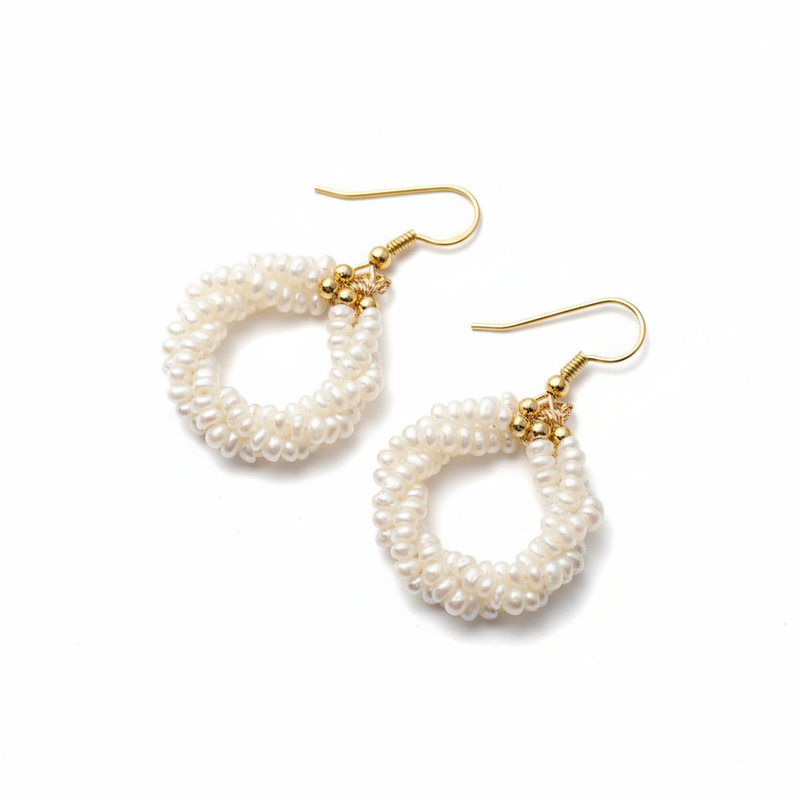 Pair of pearl hoop earrings with gold hooks on a white background