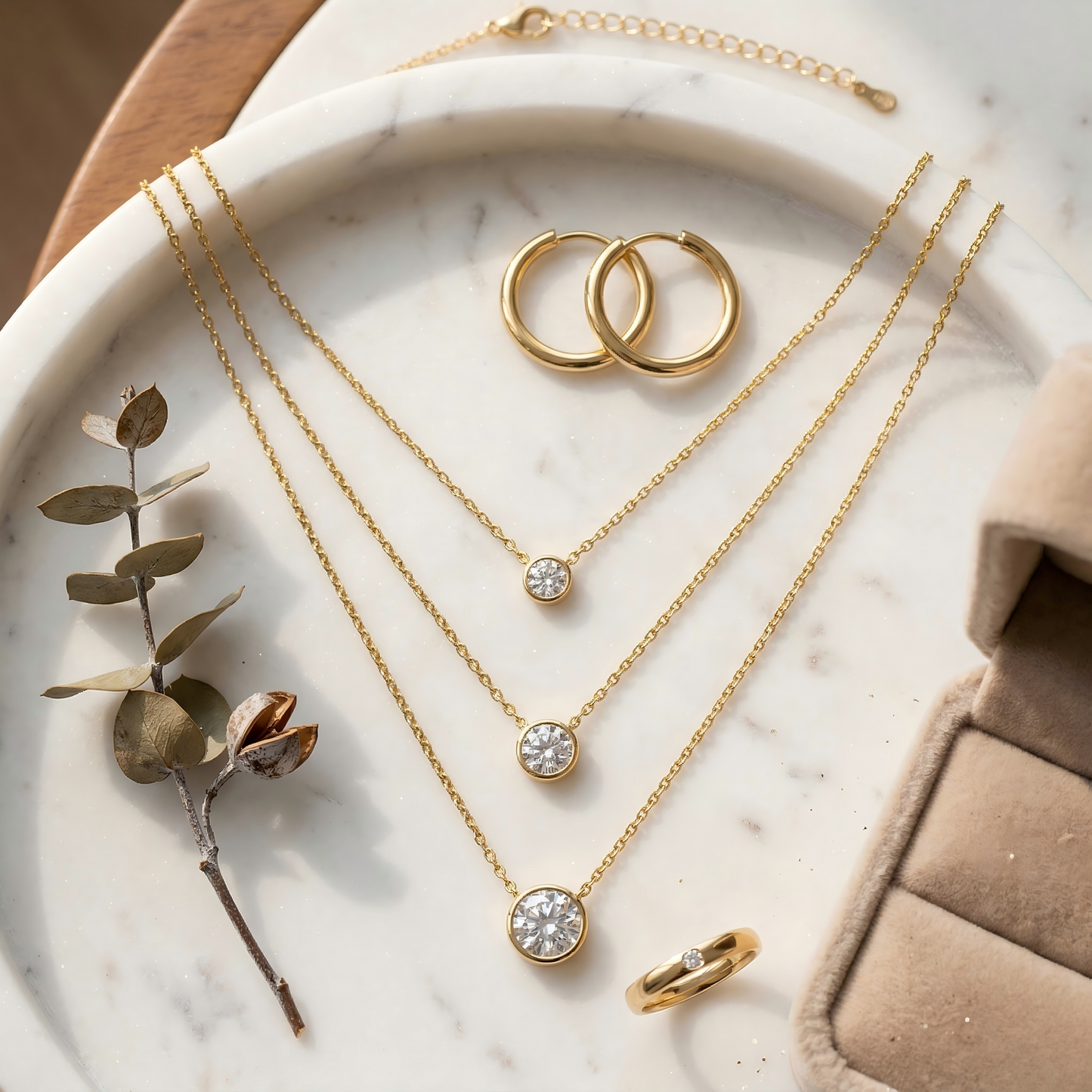 Top-down, necklaces on marble tray, styled with earrings, ring, dried flower, velvet box, warm soft tones, balanced composition, clean e-commerce aesthetic, high resolution.