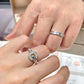 Close-up of hands wearing silver rings with a blurred background