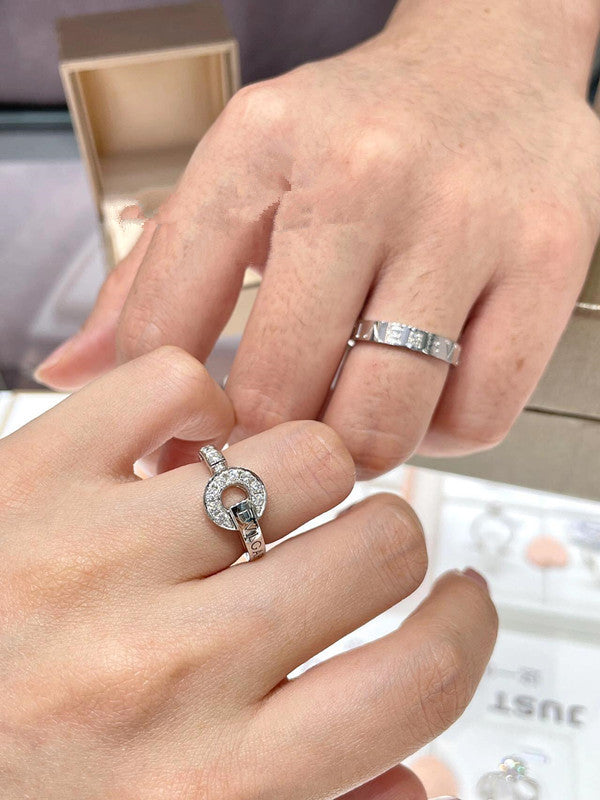 Close-up of hands wearing silver rings with a blurred background