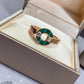 Gold ring with green stone in a jewelry box
