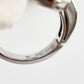 Close-up of a silver ring with 'Made in Italy' stamp on a light gray background