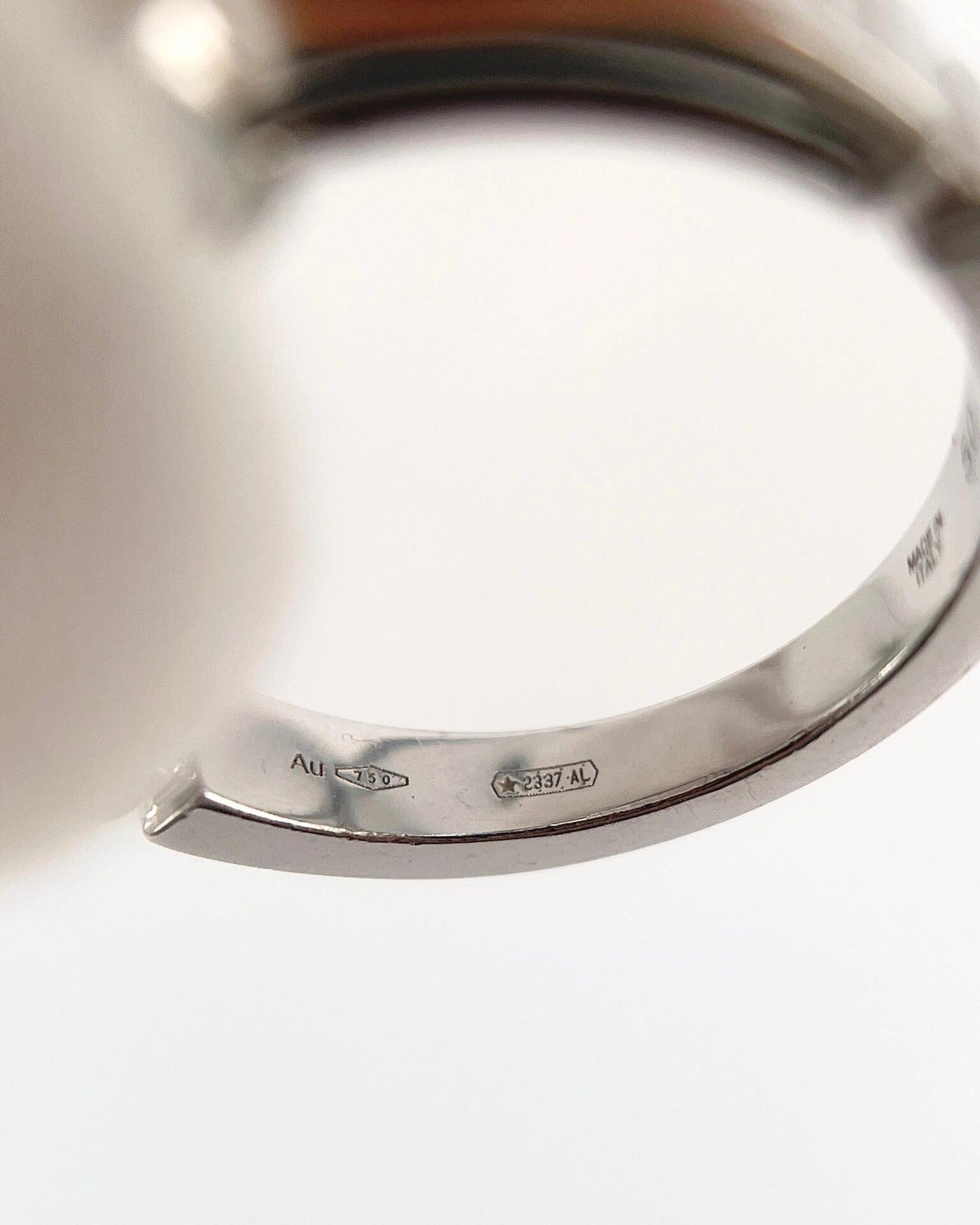 Close-up of a silver bracelet with visible hallmarking on a white background