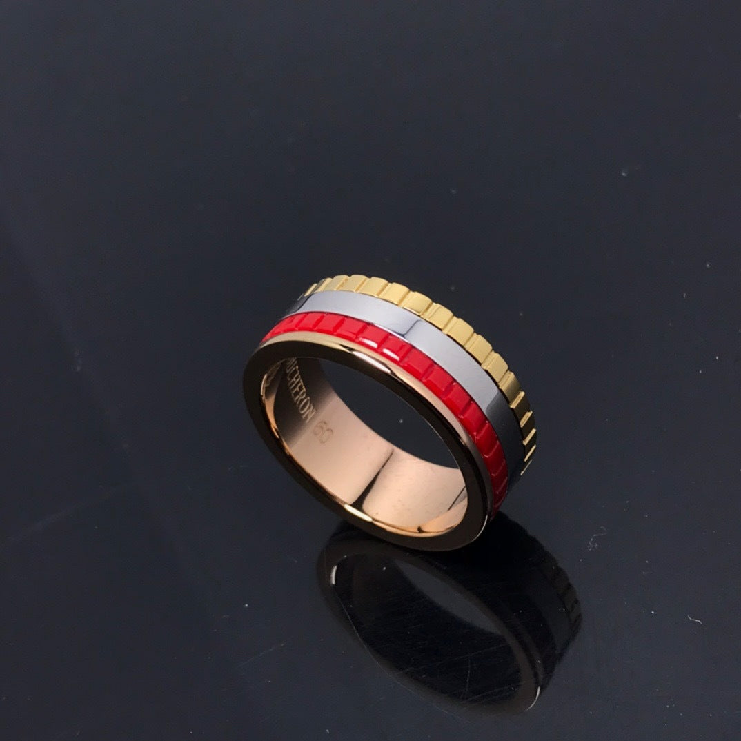 Multicolored ring with gold, silver, and red bands on a black background