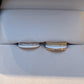 Two gold rings with diamond accents on a white jewelry box.