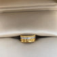 Gold ring with embedded diamonds on a beige fabric background