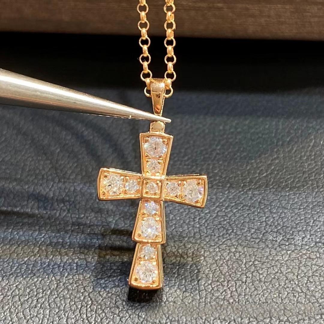 Bvlgari 18K White Gold Serpenti Cross Diamond Necklace Necklace Women Gold cross pendant with diamonds on a chain against a dark textured background