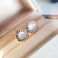 Bulgari earrings with rose gold and white stones on a soft background
