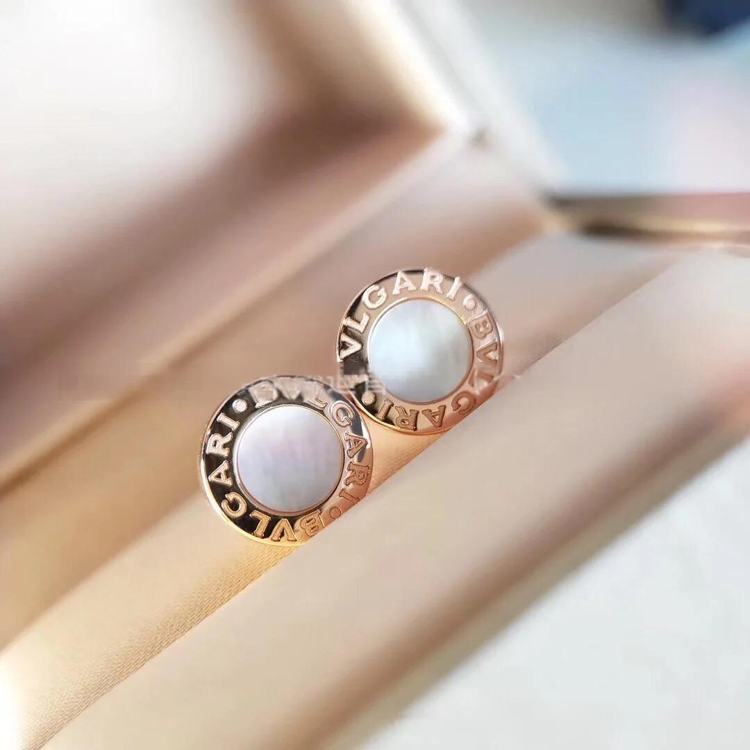 Bulgari earrings with rose gold and white stones on a soft background