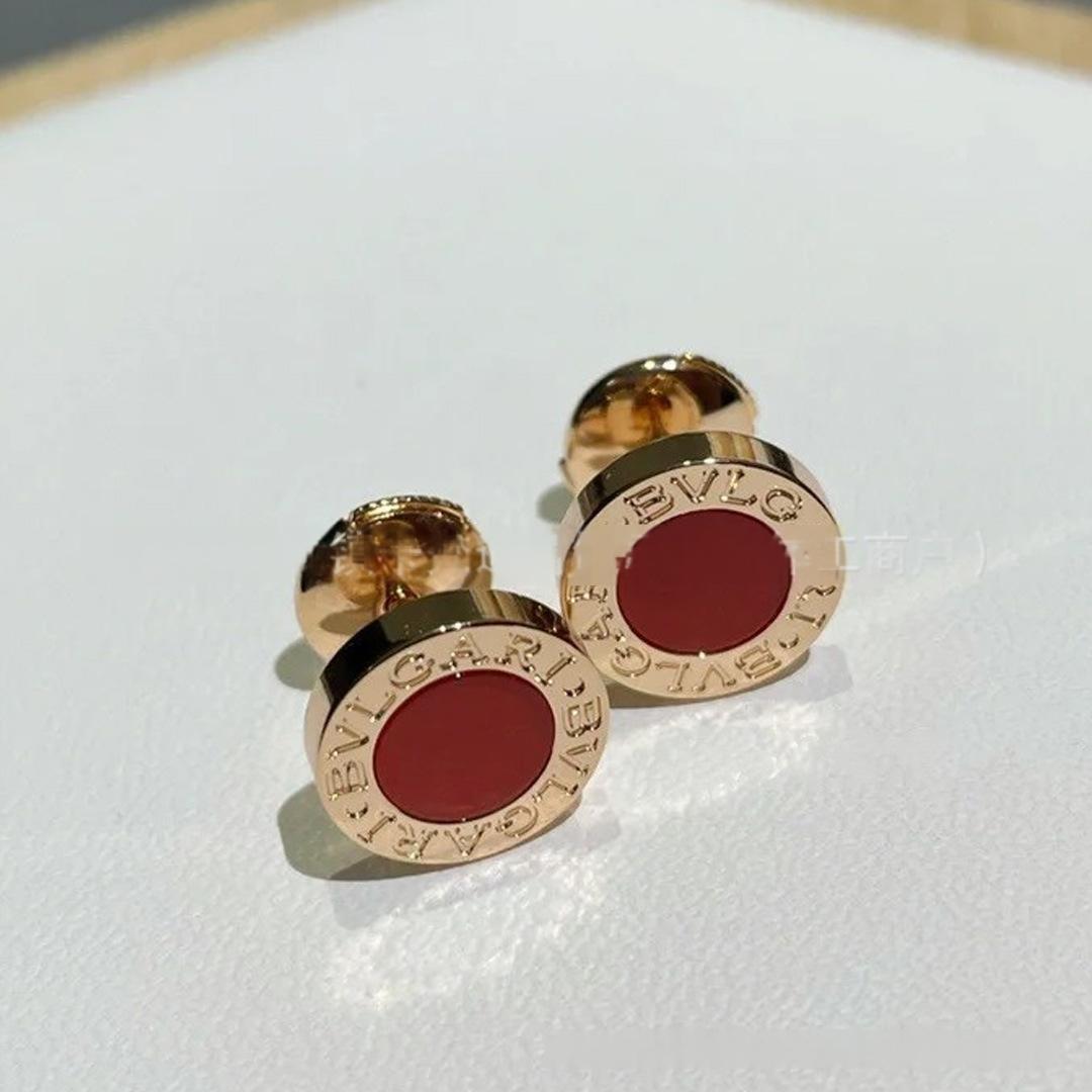 Gold cufflinks with red centers on a white background