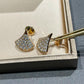 Bvlgari  Divas’ Dream Earringson a gray surface with a box in the background