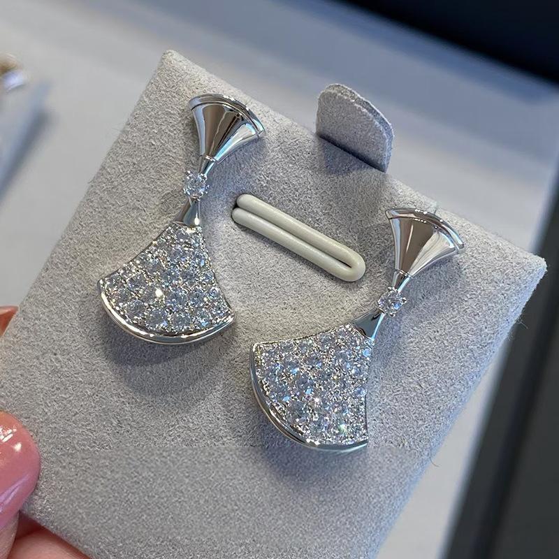 Bvlgari  Divas’ Dream Earrings with gemstones on a gray display stand.