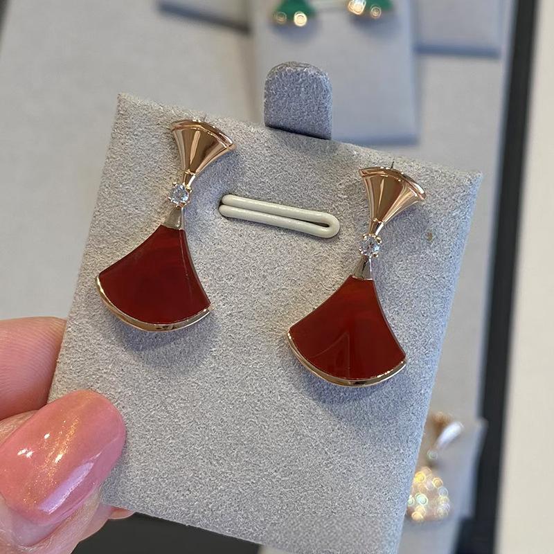 Bvlgari  Divas’ Dream Earringson a display card held by a hand with pink nail polish.