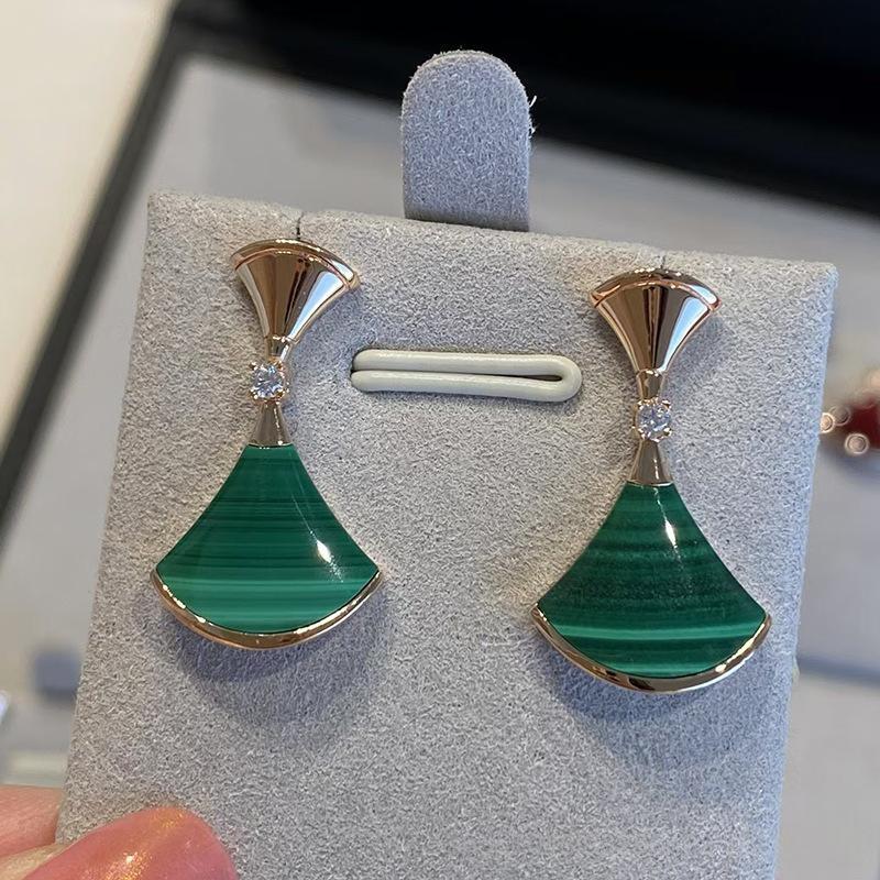 Bvlgari  Divas’ Dream Earringswith gold and silver accents on a gray earring display card.