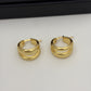 A pair of polished gold hoop earrings with a double-band twisted design, displayed on a clean white surface.