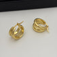 A pair of polished gold huggie hoop earrings with a triple-band design, displayed on a clean white surface.
