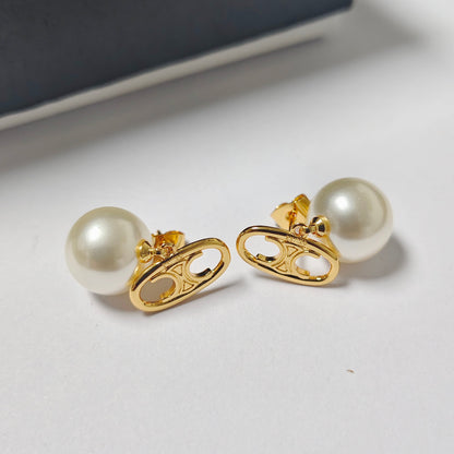 A pair of gold-tone earrings with oval cutout links and round white faux pearls, displayed on a light gray surface.