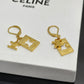 A pair of gold-tone Celine leverback earrings with a square logo charm and a small Celine Triomphe charm, displayed on a white Celine box.