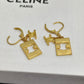 A pair of gold-tone Celine drop earrings with rectangular logo charms and leverback hooks, displayed on a white textured Celine box.