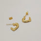 Gold-tone Celine crescent-shaped hoop earrings with the brand name engraved on the front, displayed on a light gray background.