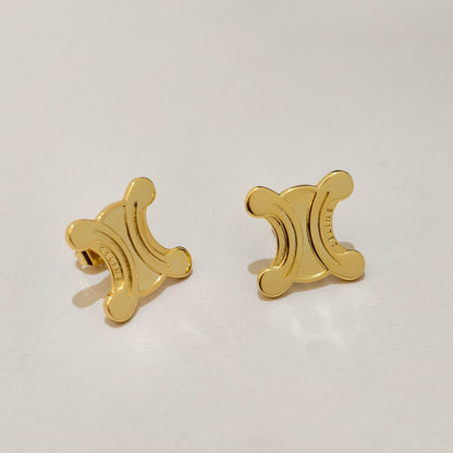 A pair of gold-tone stud earrings shaped like the Celine Triomphe symbol, shown on a clean, light off-white background.