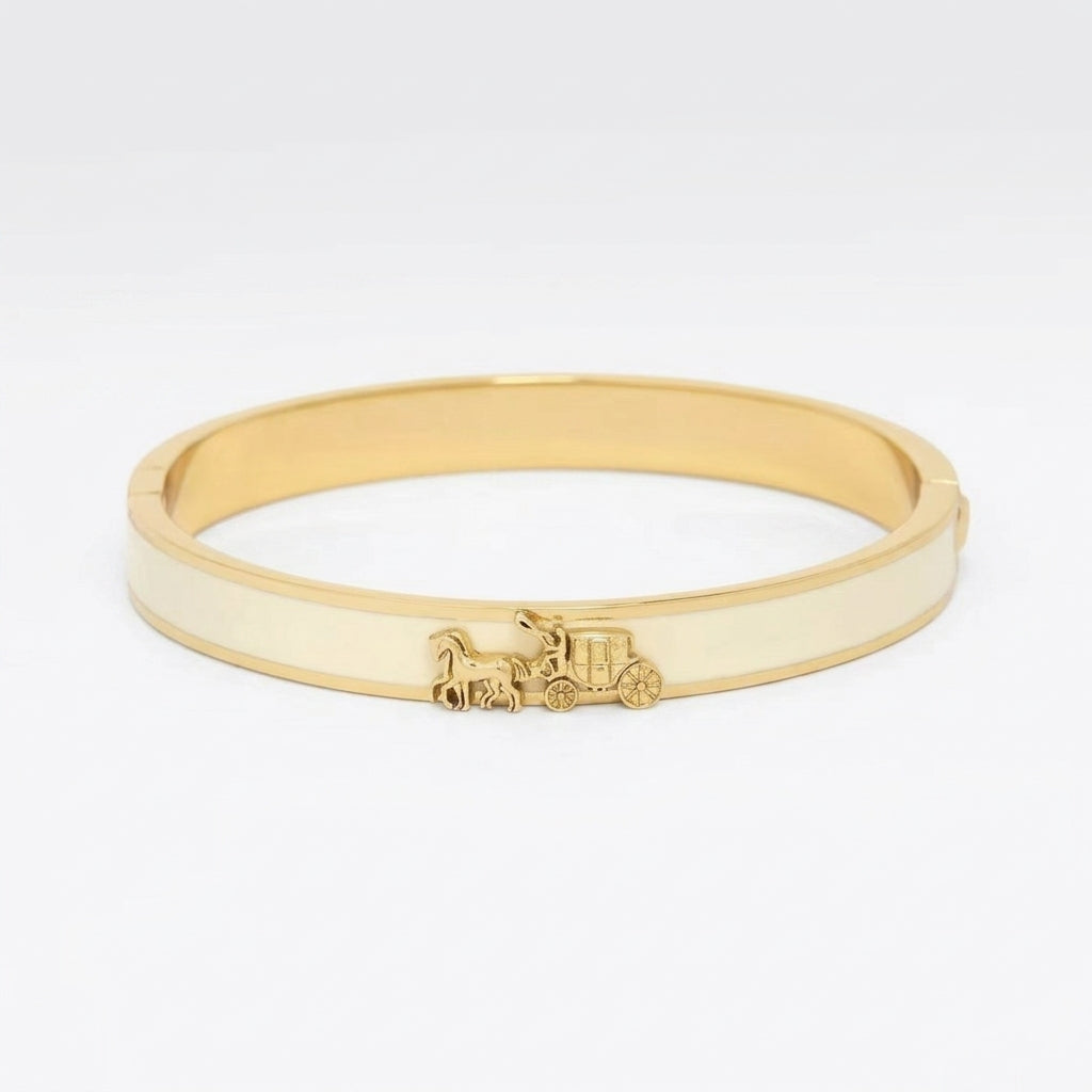 A gold-plated bangle bracelet with a cream-colored inlay and a small horse-drawn carriage charm, shown on a plain white background.