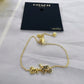 A gold-tone Coach New York bracelet featuring a horse-drawn carriage charm, displayed on its black branded hang card over a light gray fabric background.
