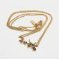 A gold-tone double-strand necklace featuring a detailed horse-drawn carriage pendant with black enamel accents, displayed on a clean white background.