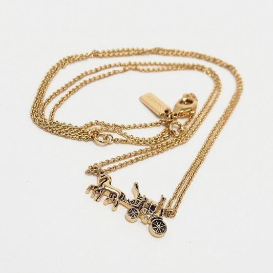 A gold-tone double-strand necklace featuring a detailed horse-drawn carriage pendant with black enamel accents, displayed on a clean white background.