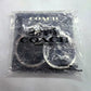 A Coach New York branded clear plastic polybag containing a pair of silver-toned metal key rings, photographed on a white background.