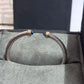 Silver bracelet with blue stones on a gray surface