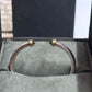 Silver bracelet with gold accents on a gray surface